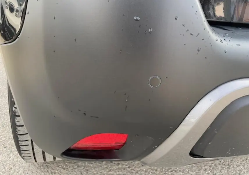 Gros plan sur le coin arrière droit noir mat du Citroën C3 Aircross avec feu rouge et pare-chocs gris.