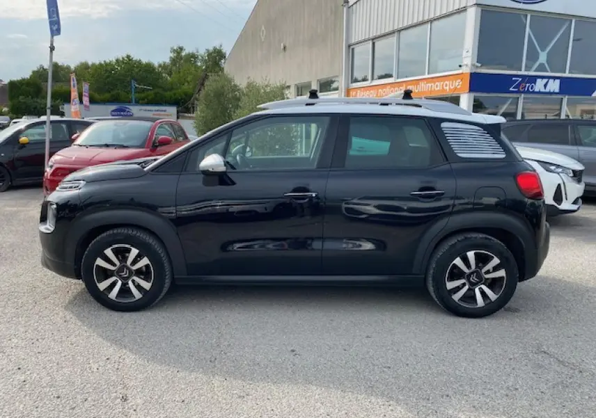 Profil côté gauche d'un Citroën C3 Aircross noir 2019 avec toit blanc et jantes distinctives en concession.
