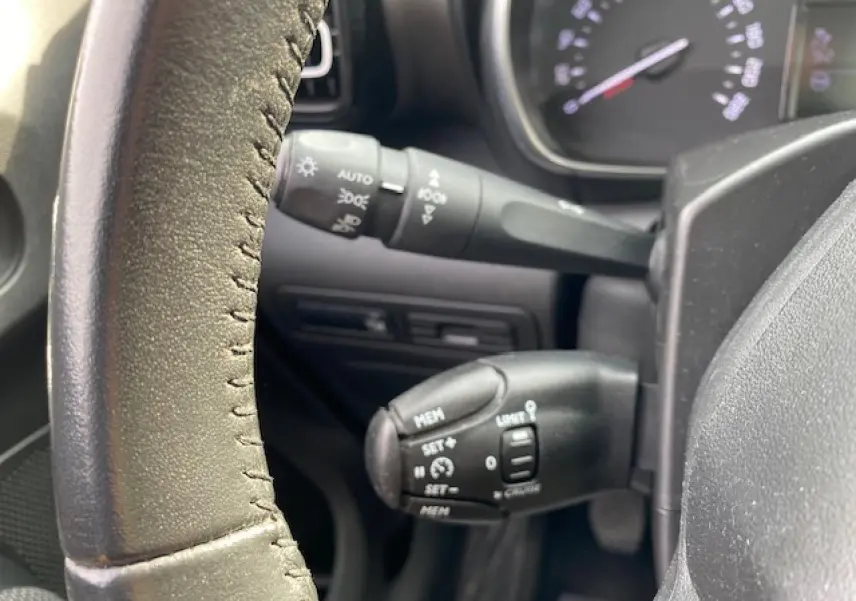 Gros plan sur les commandes au volant en croûte de cuir du Citroën C3 Aircross 2019, version diesel noire.