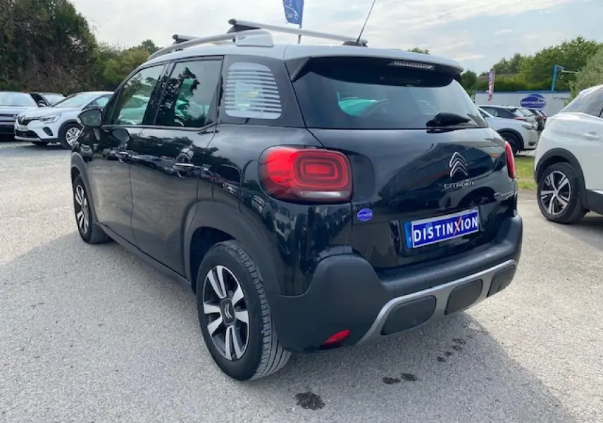Vue 3/4 arrière droite d'un Citroën C3 Aircross noir avec toit blanc et feux arrière LED distinctifs.
