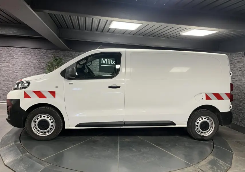 Profil droit du Citroën Jumpy blanc avec bandes réfléchissantes rouges et blanches sur ailes avant et arrière.