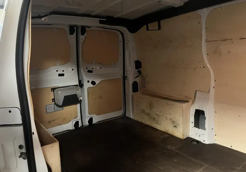 Intérieur du coffre du Citroën Jumpy blanc, vue arrière avec habillage bois et espace de chargement vide.