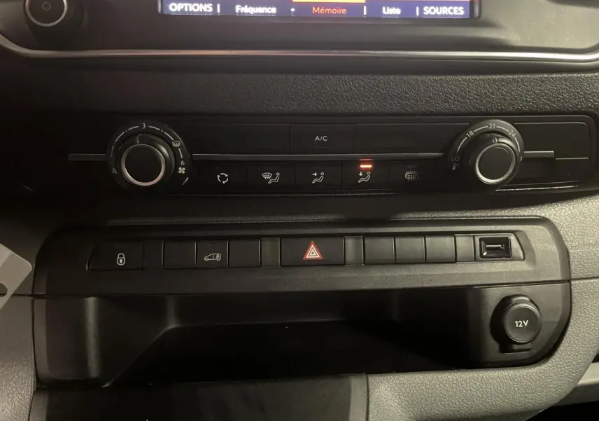 Gros plan sur la console centrale noire du Citroën Jumpy 2019 avec commandes climatisation et bouton hazard allumé.
