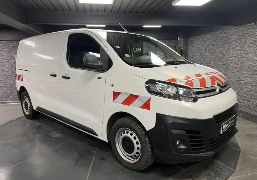Vue 3/4 avant d'un Citroën Jumpy blanc avec marquages rouges réfléchissants sur capot et ailes avant.