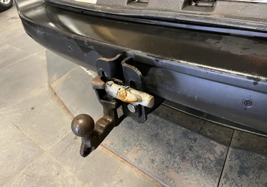 Gros plan sur l'attelage crochet mixte arrière noir du Citroën Jumpy blanc, avec pare-chocs noir teinté masse visible.