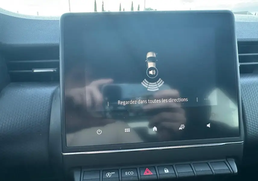 Écran tactile central affichant l'aide au stationnement dans l'habitacle d'une Renault Clio gris foncé 2022.
