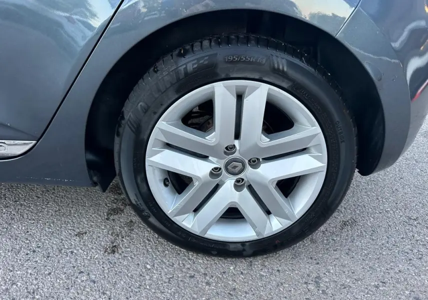 Gros plan sur la roue arrière droite d'une Renault Clio gris foncé, mettant en valeur la jante alliage au design moderne.