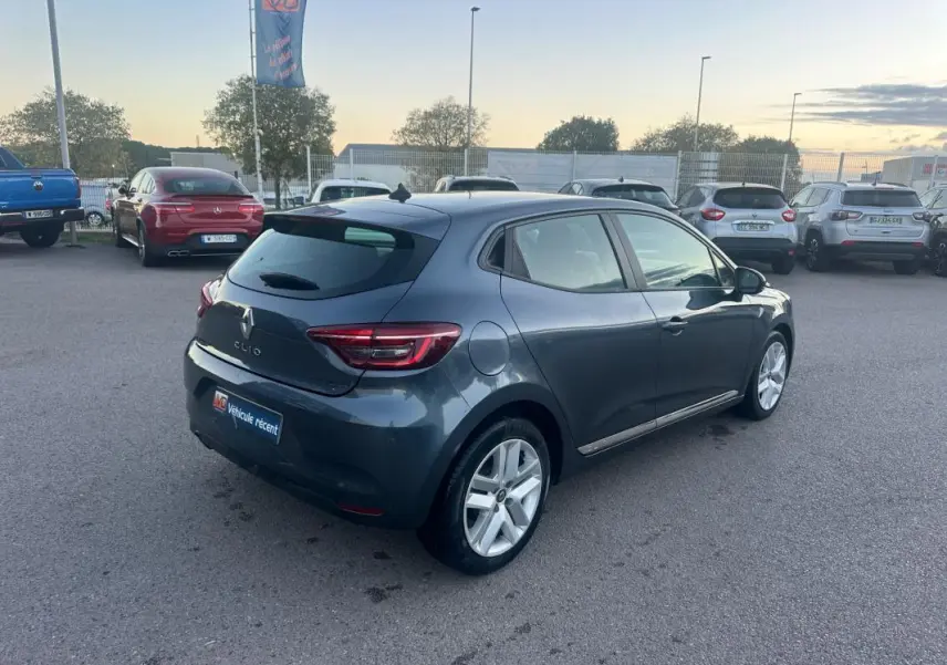 Renault Clio gris foncé vue 3/4 arrière droit sur parking avec feux arrière LED et jantes alliage.