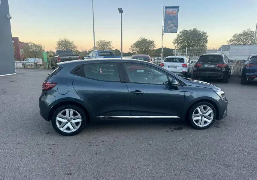 Profil droit d'une Renault Clio gris foncé 2022 garée, mettant en valeur ses lignes fluides et ses jantes alliage.