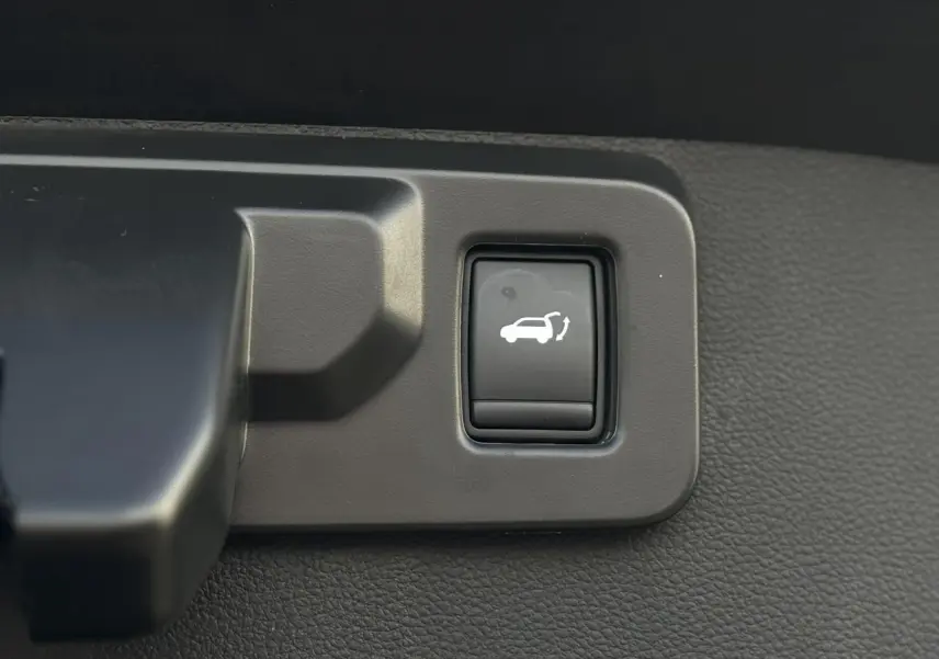 Bouton noir d'ouverture du hayon mains libres dans l'habitacle du Renault Symbioz E-Tech Full Hybrid 2025.