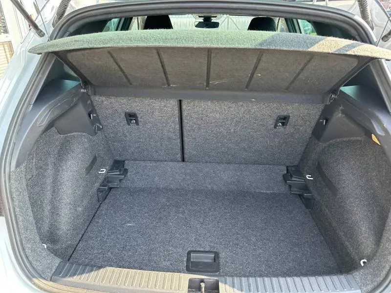 Vue intérieure du coffre ouvert du SEAT Arona 2025, revêtement gris et espace de rangement spacieux visible.