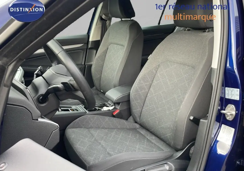 Vue intérieure côté gauche montrant les sièges tissu gris et le volant d'une Volkswagen Golf VIII bleu lapiz metal 2023.