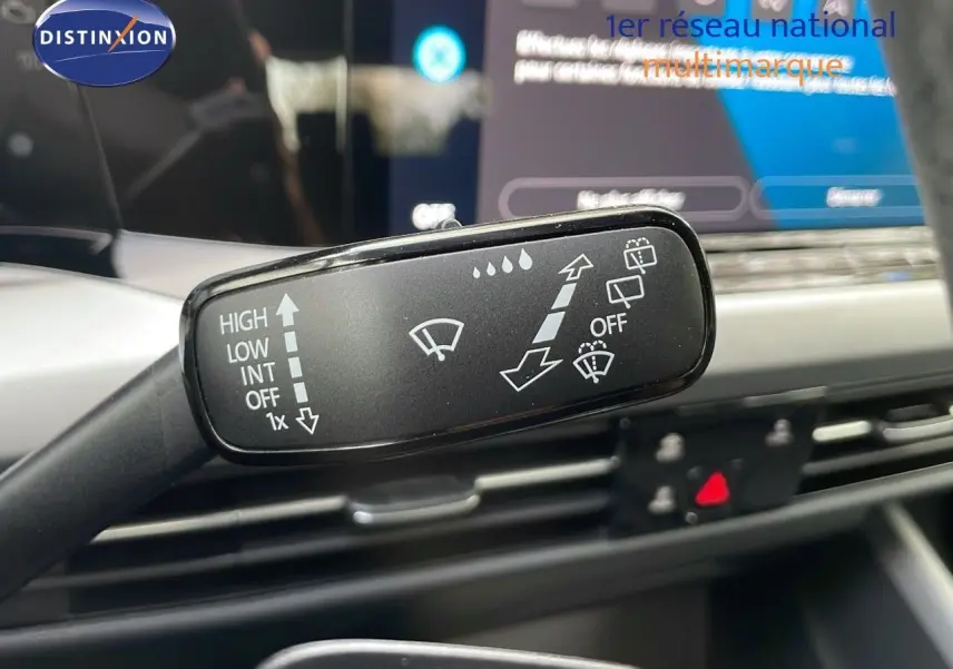 Gros plan sur la commande d'essuie-glace de la Volkswagen Golf VIII bleu lapiz metal, intérieur moderne et écran tactile visible.