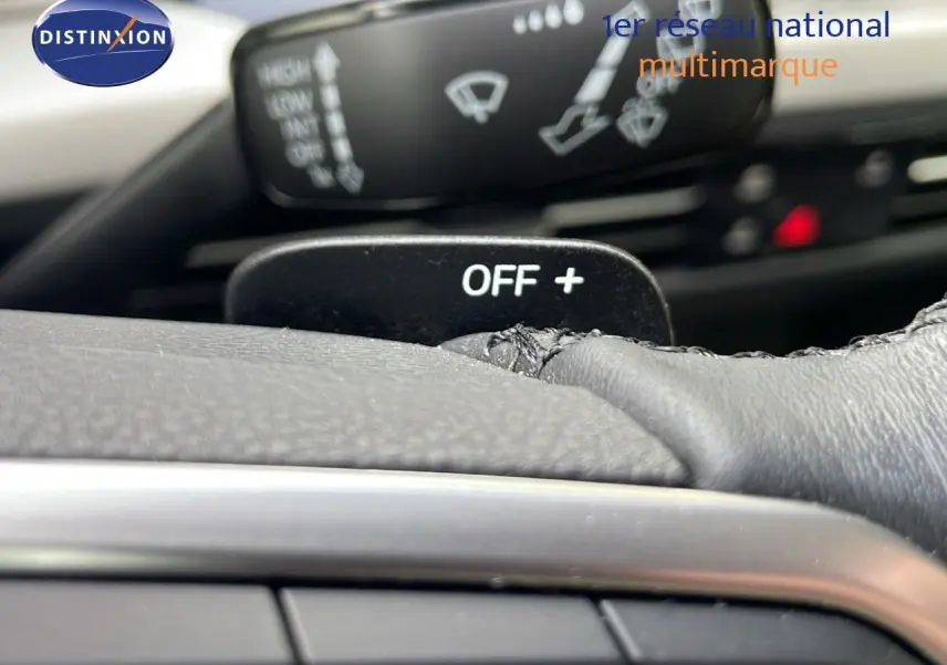 Gros plan sur la commande au volant d'une Volkswagen Golf VIII bleu lapiz metal, mettant en valeur le bouton OFF+ et les commandes d'essuie-glace.