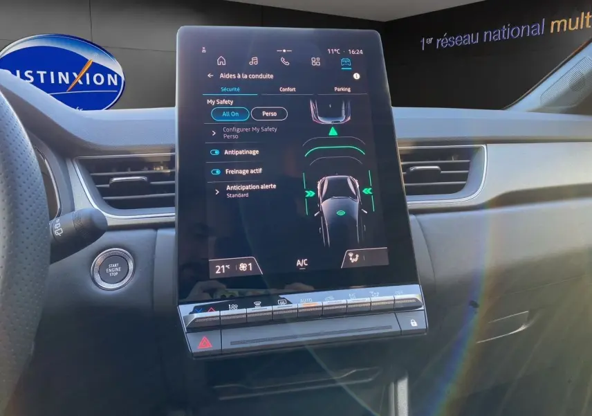 Vue intérieure du tableau de bord du Renault Captur 2025, écran tactile central affichant les aides à la conduite.