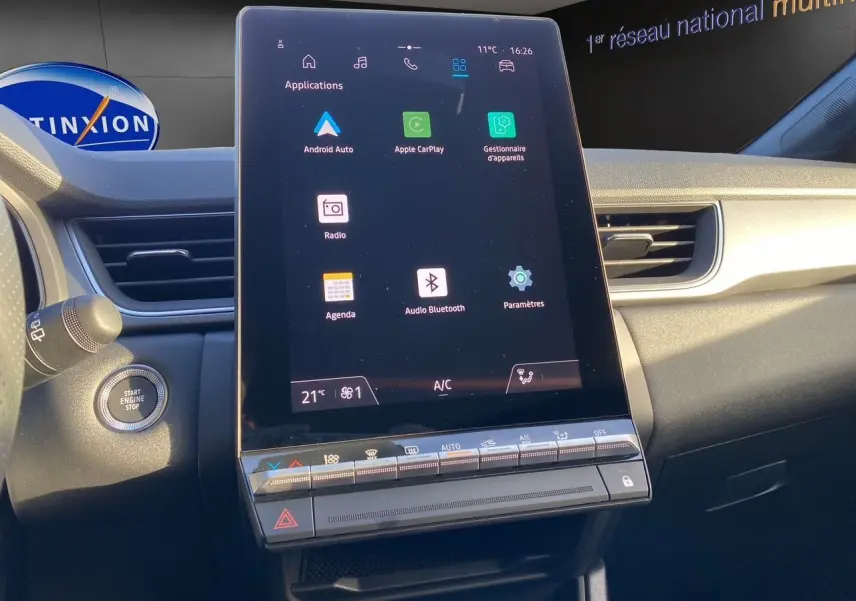 Vue intérieure du tableau de bord du Renault Captur 2025, écran tactile central avec interface multimédia et commandes climatisation.