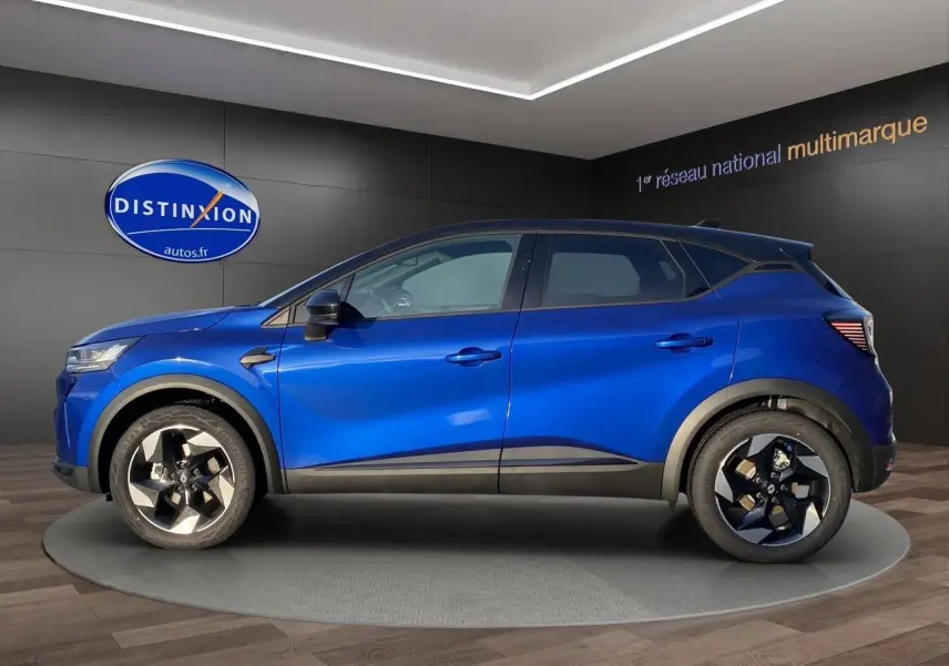 Vue de profil côté gauche du Renault Captur 2025 bleu Iron avec toit noir et jantes distinctives noires et argentées.