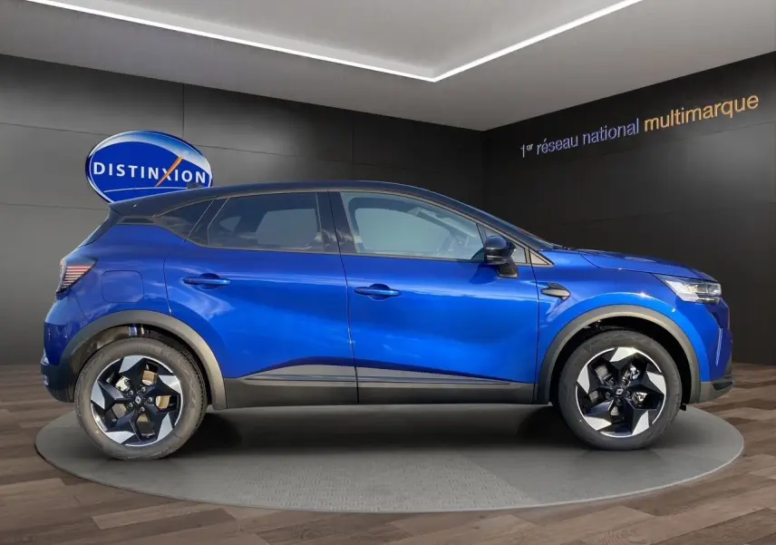 Vue de profil côté gauche du Renault Captur 2025 bleu Iron avec toit noir, soulignant ses jantes distinctives.