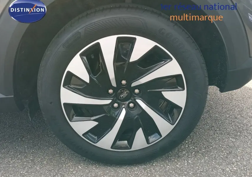 Gros plan sur la roue avant droite du Ford Puma gris foncé métal, mettant en valeur la jante bicolore au design moderne.