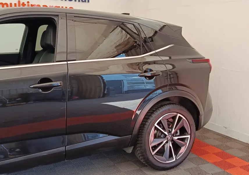 Vue côté droit arrière du Nissan Qashqai noir 2023, mettant en valeur les jantes alliage et la ligne de toit dynamique.