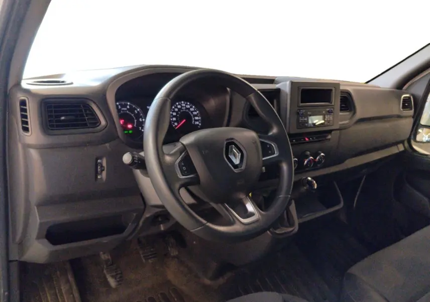 Vue intérieure côté conducteur du Renault Master 2023, tableau de bord noir avec volant multifonction et commandes visibles.