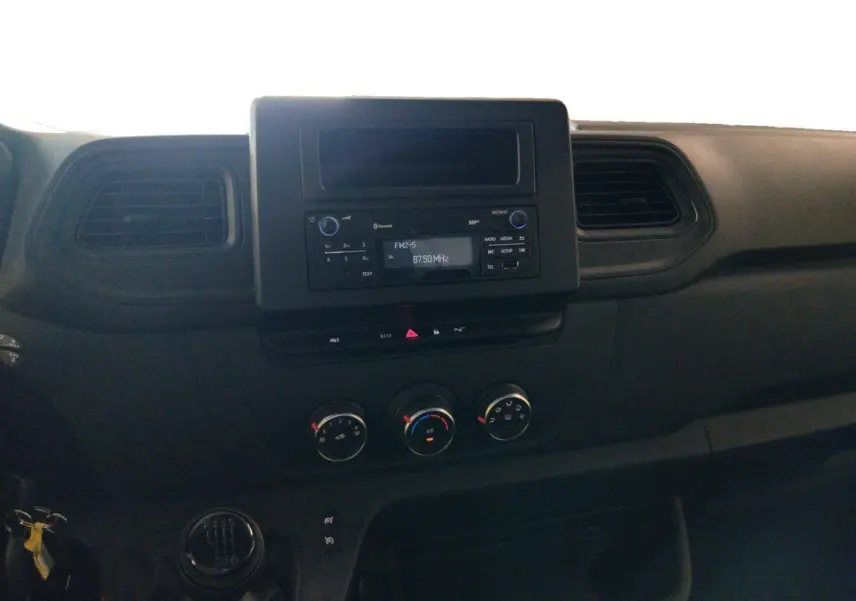 Vue intérieure du tableau de bord du Renault Master 2023, avec console centrale noire et commandes manuelles de climatisation.