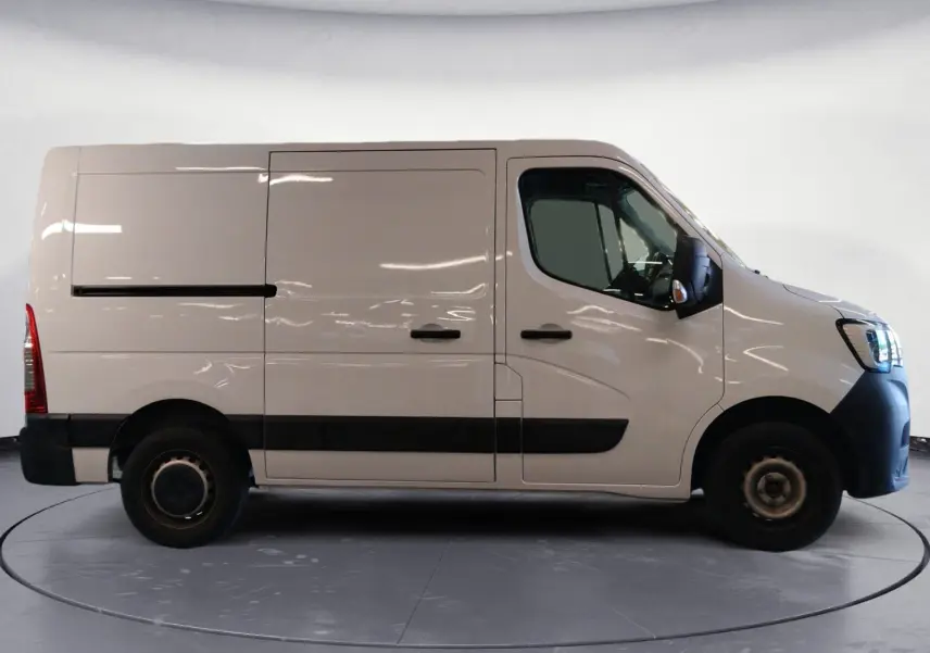 Vue latérale droite d’un Renault Master blanc 2023, fourgon utilitaire avec porte coulissante et protections noires sur les bas de caisse.
