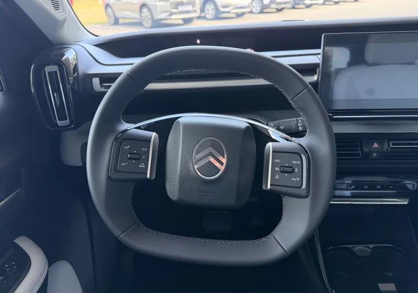 Vue intérieure centrée sur le volant noir de la Citroën E-C3 113 MAX 2025 avec tableau de bord et écran tactile.