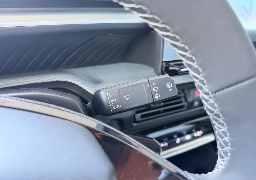 Gros plan sur la commande des essuie-glaces côté gauche du volant d'une Citroën C3 E-C3 113 MAX 2025, intérieur noir.