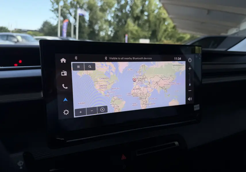 Écran tactile du GPS affichant une carte du monde dans l'habitacle d'une Citroën E-C3 113 MAX gris Mercury.