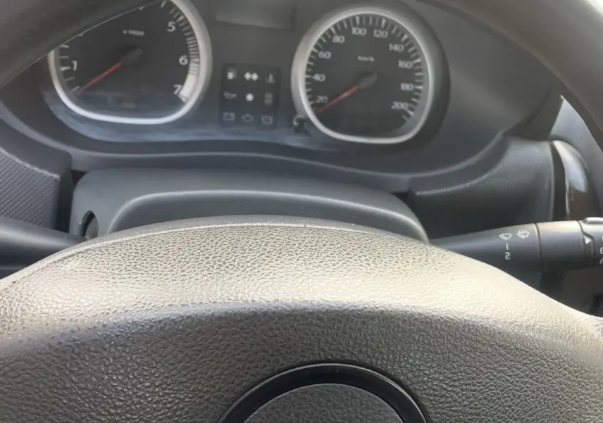 Vue rapprochée du tableau de bord et du volant noir du Dacia Duster 2011 avec compte-tours et compteur de vitesse.