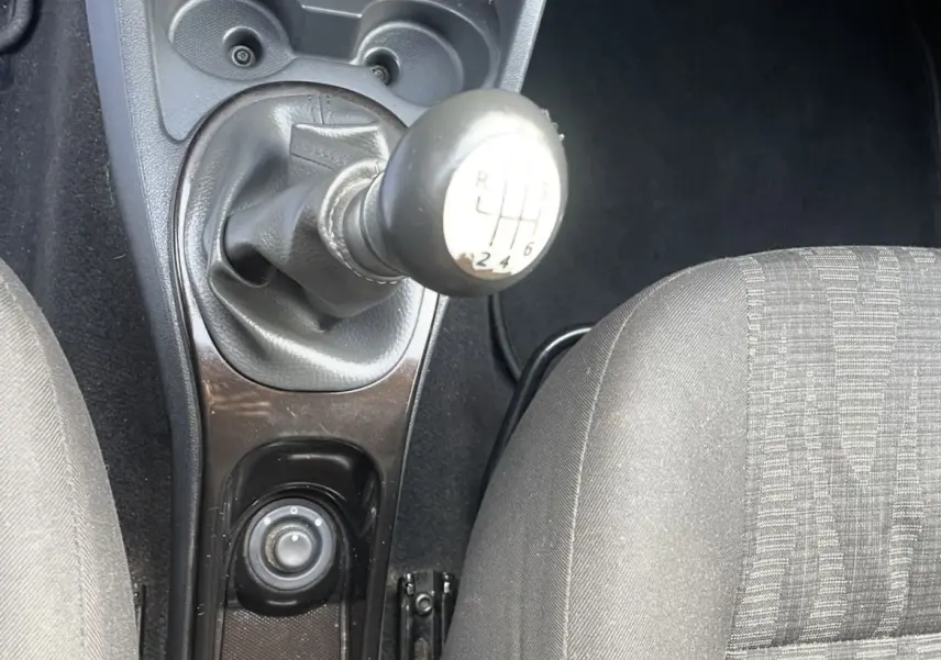 Vue rapprochée de la console centrale du Dacia Duster 2011, montrant levier de vitesses manuel et sièges gris.