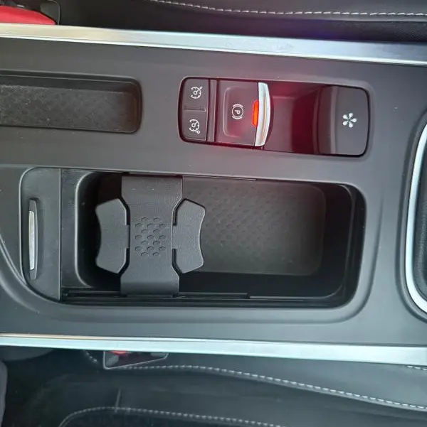 Vue rapprochée de la console centrale noire avec frein à main électrique et rangement sur Renault Mégane IV gris clair.