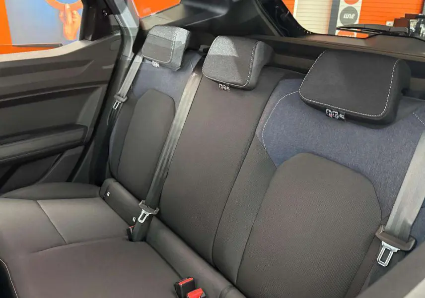 Vue intérieure de la banquette arrière du Dacia Duster noir nacré 2026, avec ceintures et appuie-têtes visibles.