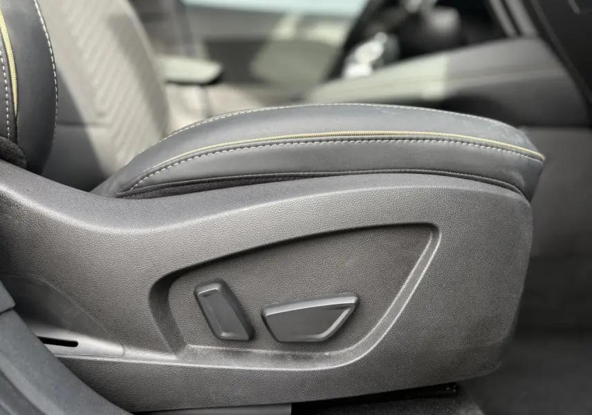 Détail des commandes de réglage électrique du siège conducteur en cuir noir avec surpiqûres jaunes du Renault Symbioz bleu Iron.