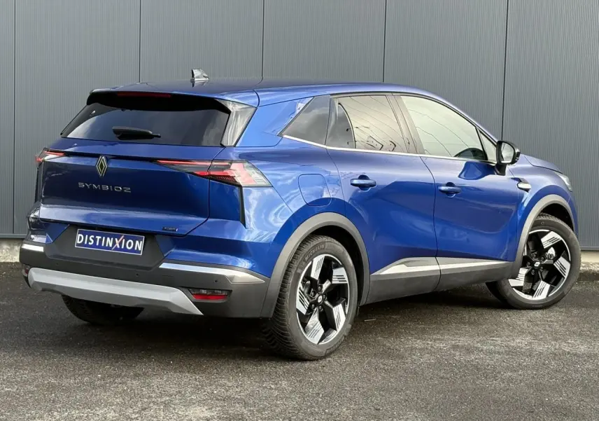 Vue 3/4 arrière droite d'un Renault Symbioz bleu Iron avec jantes 18 pouces et hayon mains libres.