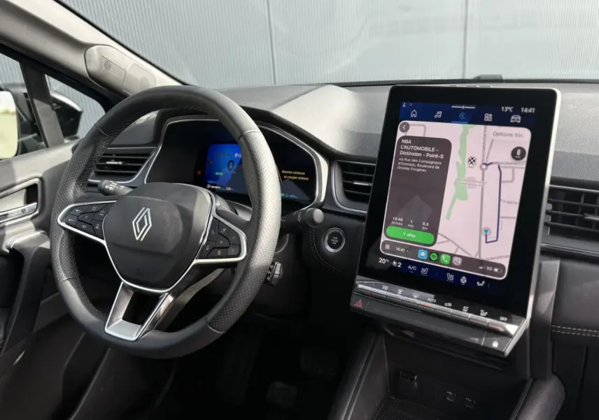 Vue intérieure du tableau de bord Renault SYMBIOZ 2025, volant multifonction et écran tactile vertical avec navigation affichée.