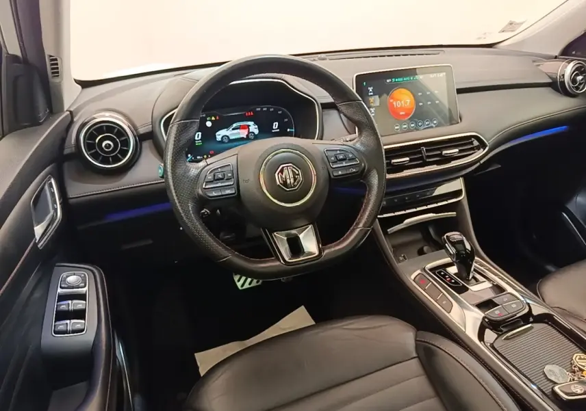 Vue intérieure avant du tableau de bord et volant cuir noir du MG Motor EHS 1.5T PHEV avec écran tactile central.