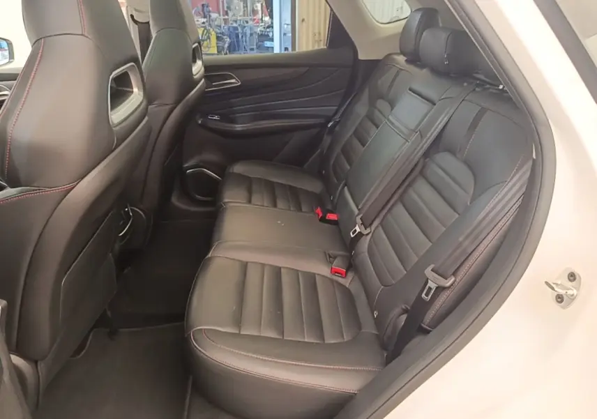 Vue intérieure côté droit sur la banquette arrière en cuir noir avec surpiqûres rouges du MG MOTOR EHS blanc 2023.