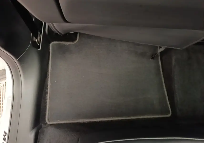 Tapis de sol gris foncé côté passager arrière dans l’habitacle du MG MOTOR EHS blanc hybride rechargeable.
