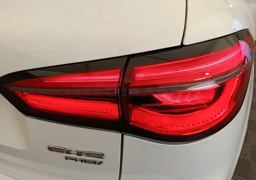 Gros plan sur le feu arrière droit rouge du MG MOTOR EHS blanc 2023 avec logo EHS PHEV visible sur la carrosserie.