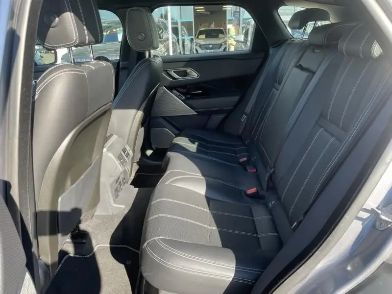 Vue intérieure côté droit des sièges arrière en cuir noir avec surpiqûres blanches du Range Rover Velar gris métal 2020.