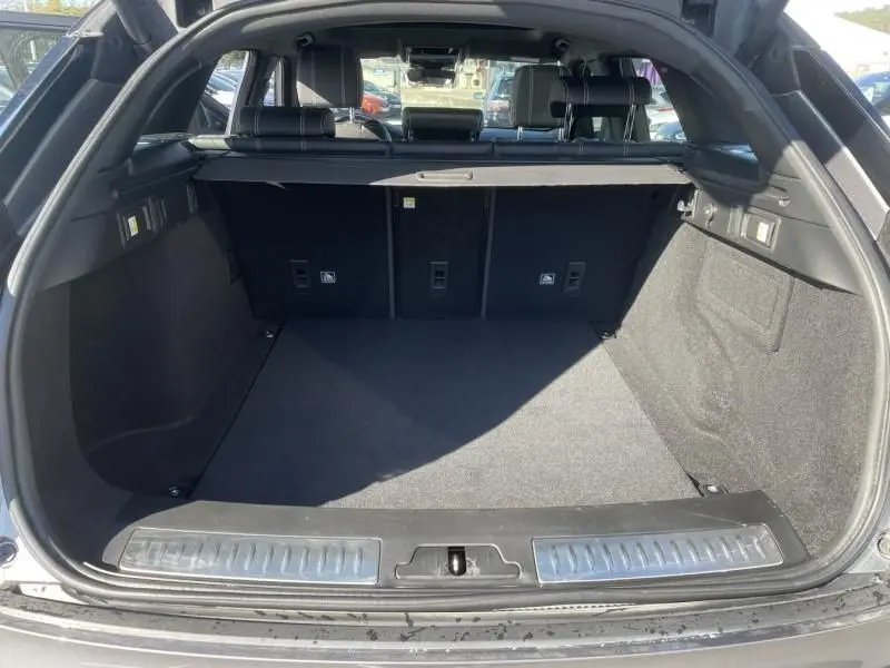 Coffre ouvert vu de l'arrière d'un Range Rover Velar gris métal 2020, montrant un espace de chargement propre et spacieux.