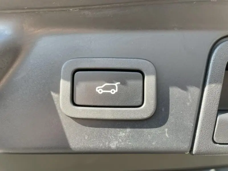 Bouton intérieur noir avec pictogramme blanc d'ouverture du coffre sur un Range Rover Velar gris métal 2020.