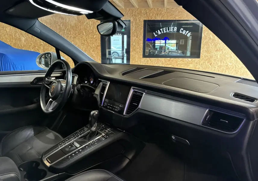 Intérieur noir du Porsche Macan GTS 2017 vu côté conducteur, avec tableau de bord et console centrale élégants.