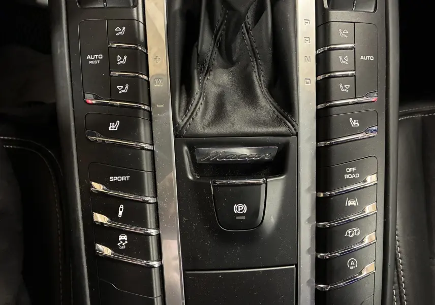 Vue rapprochée de la console centrale noire du Porsche Macan GTS 2017 avec levier de vitesses et boutons de commande.