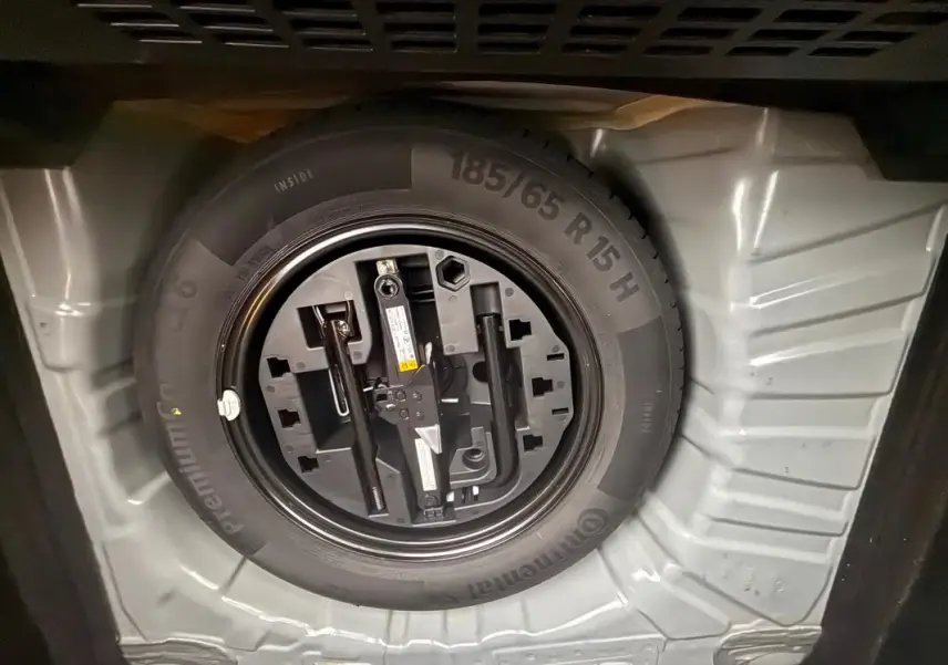 Roue de secours et outillage rangés dans le coffre d'une Renault Clio gris foncé V TCe 90 Equilibre 2022.