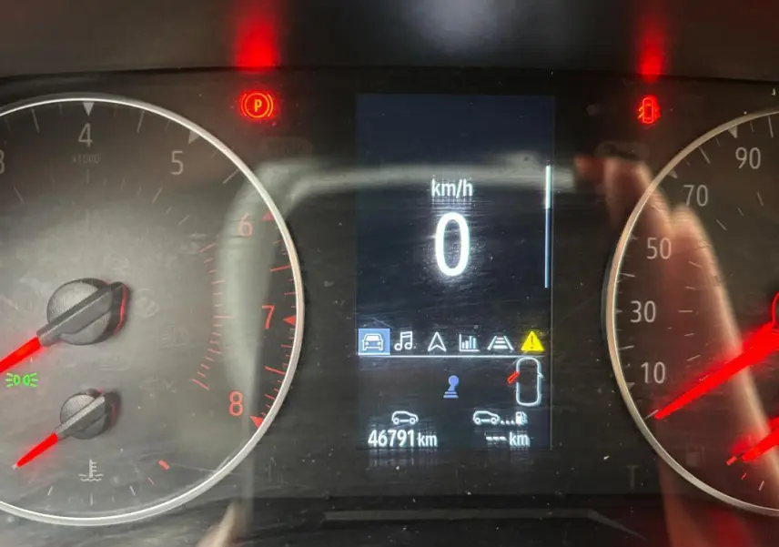 Tableau de bord de Renault Clio gris foncé 2022 montrant vitesse à 0 km/h et témoin porte ouverte allumé.