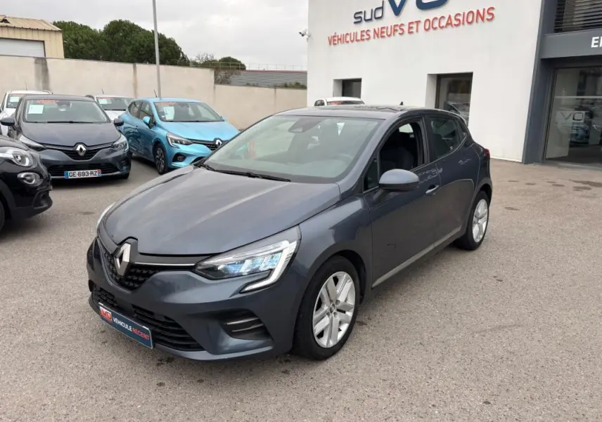 Renault Clio V TCe 90 gris foncé vue 3/4 avant droit sur parking devant concession sud VO.