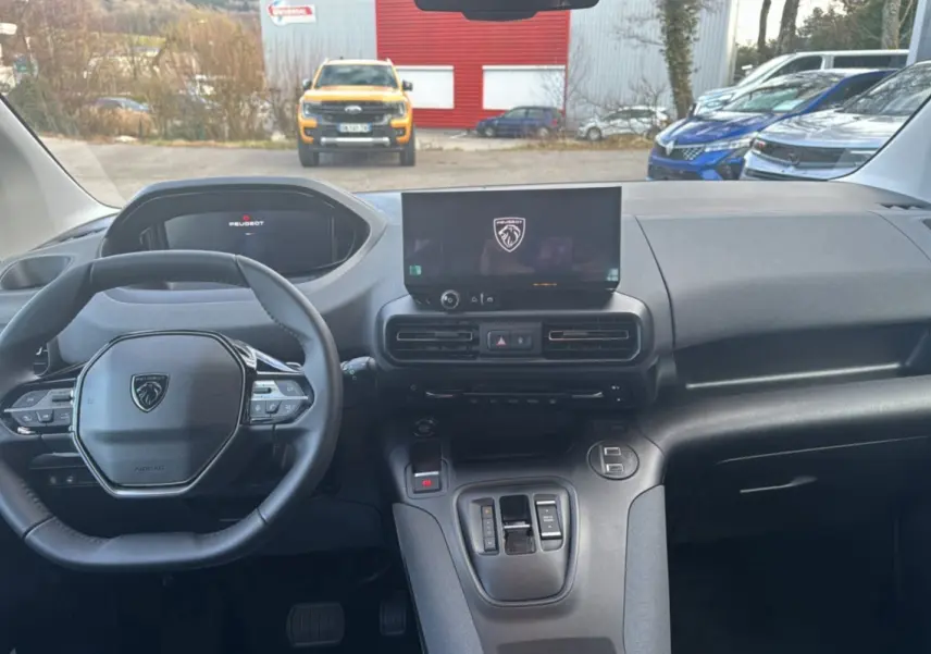 Vue intérieure du tableau de bord du Peugeot Rifter 2026 avec volant cuir multifonctions et écran tactile central.